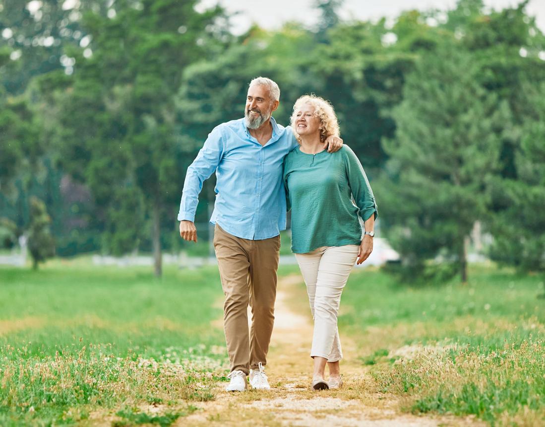 Twee volwassenen wandelen samen buiten over een pad in het park